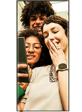 group of three share a laugh watching a video