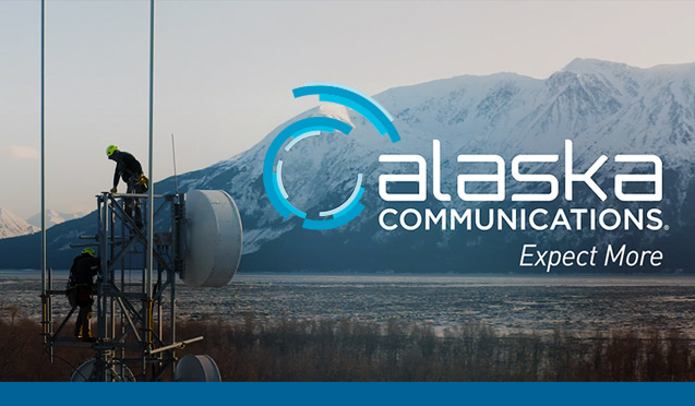 Communications workers atop a tower overlooking Turnagain Arm with the snow-capped Kenai Mountains in the distance