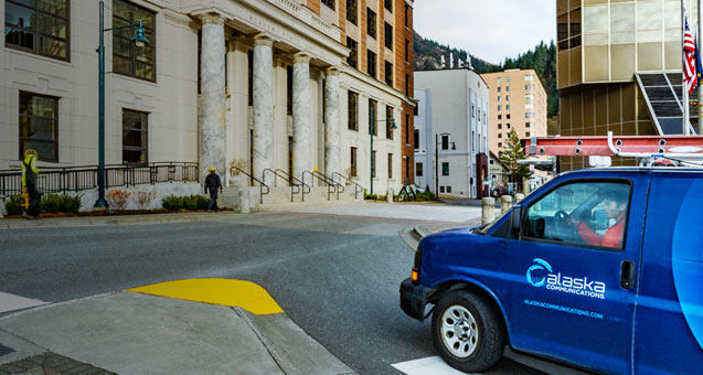 AN Alaska Communications service van passes the State Capitol Building in Juneau, Alaska