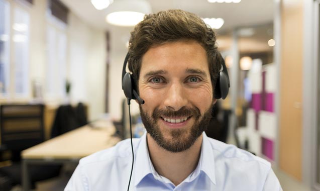Young office worker talking on his VoIP phone system