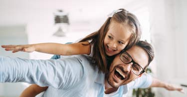 A young girl pretends she's flying with arms outstretched