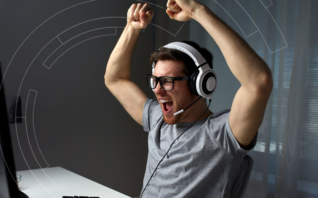 Computer gamer holds his hands above head triumphantly
