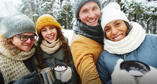 Friends drinking hot cocoa while on an outdoor adventure